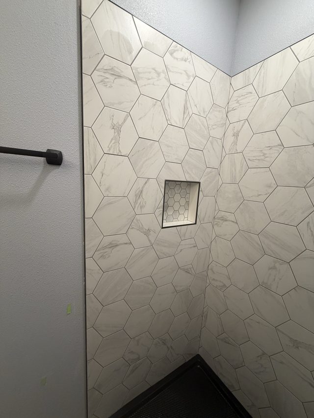 white marble hexagon tile shower with recessed niche