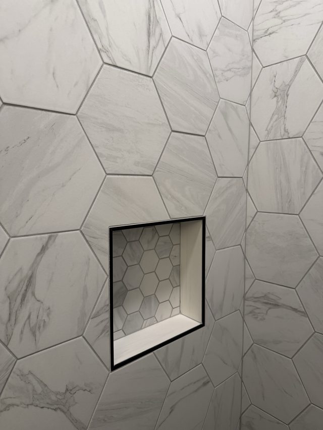 marble hexagon tile shower wall with niche
