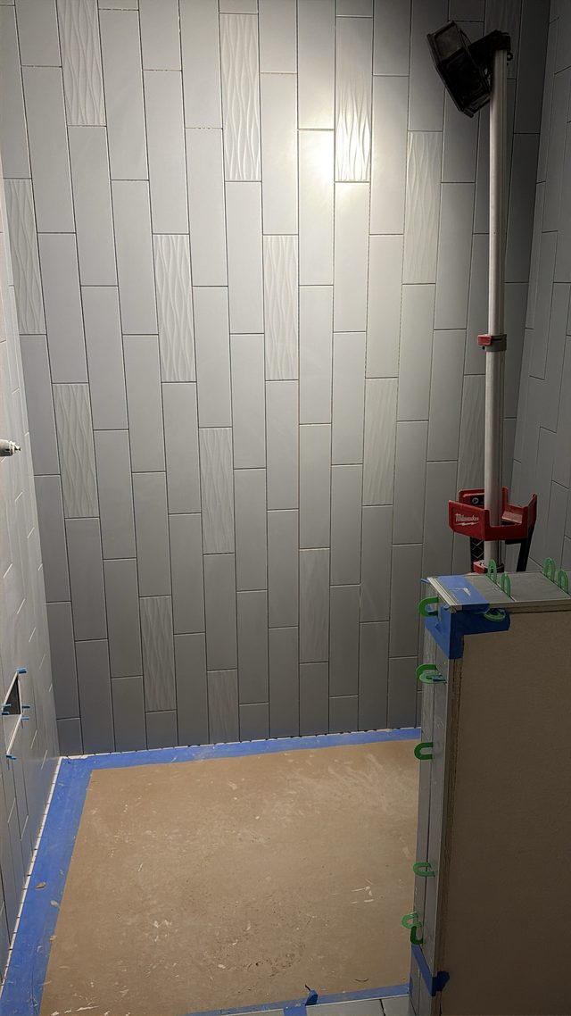 gray tile shower stall in progress, taped floor