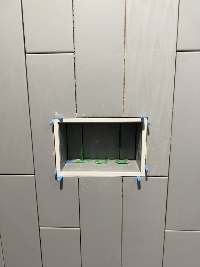 gray tile shower niche close-up with spacers, in progress
