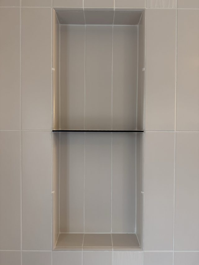 white tile shower niche with shelf