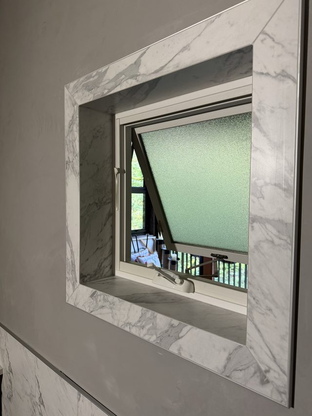 marble-tiled window niche on bathroom wall