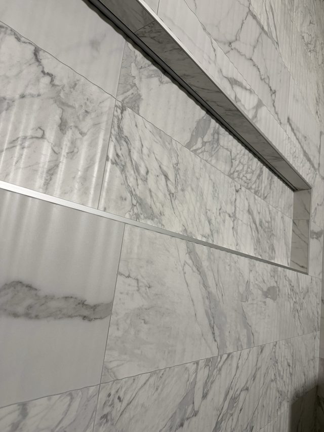 close-up of marble shower wall tile with recessed niche
