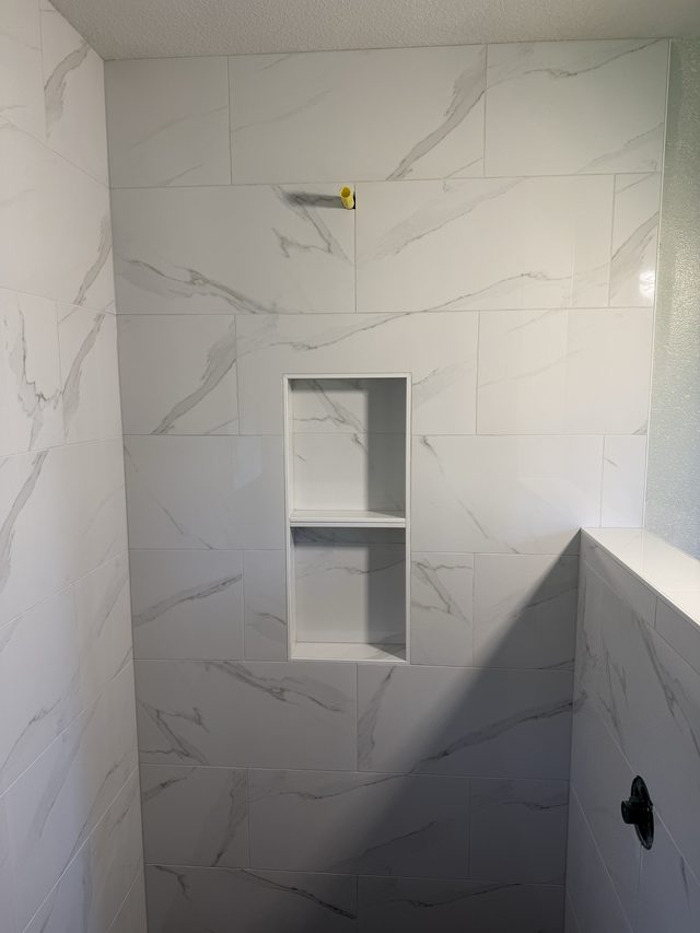 white marble shower wall with recessed niche