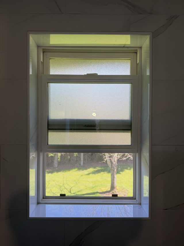 window surrounded by marble bathroom wall tile