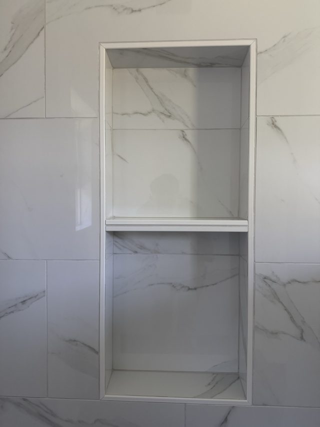 marble shower wall with two-tier recessed niche