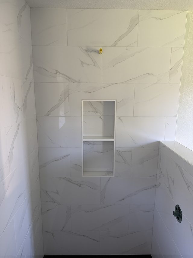 marble shower wall with recessed niche and valve