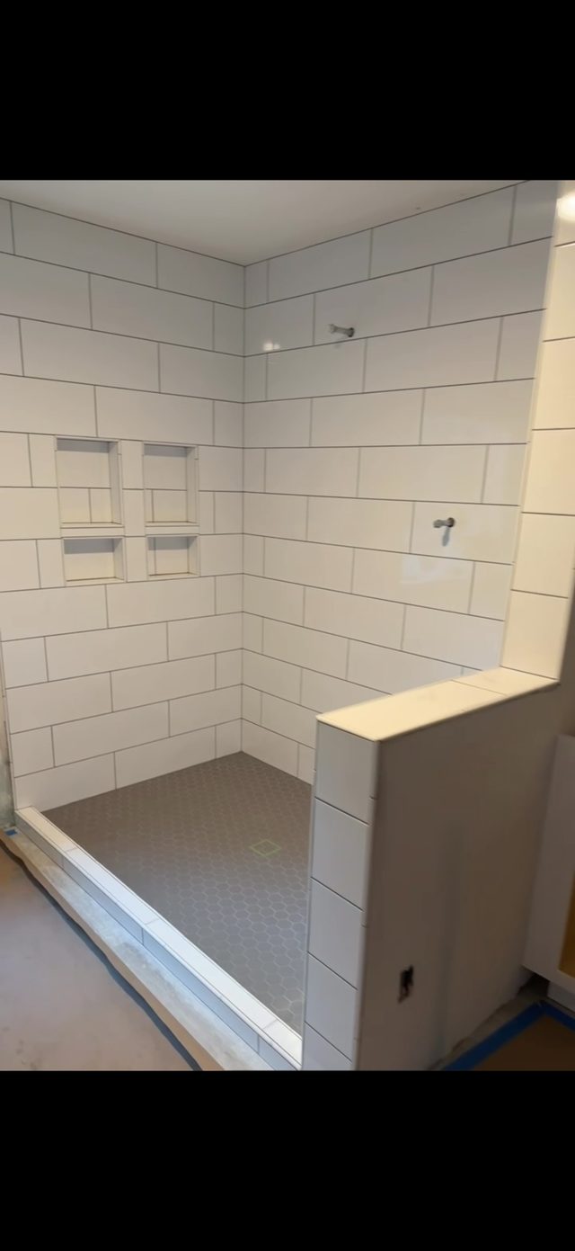 white subway tile shower with niches and tiled pan