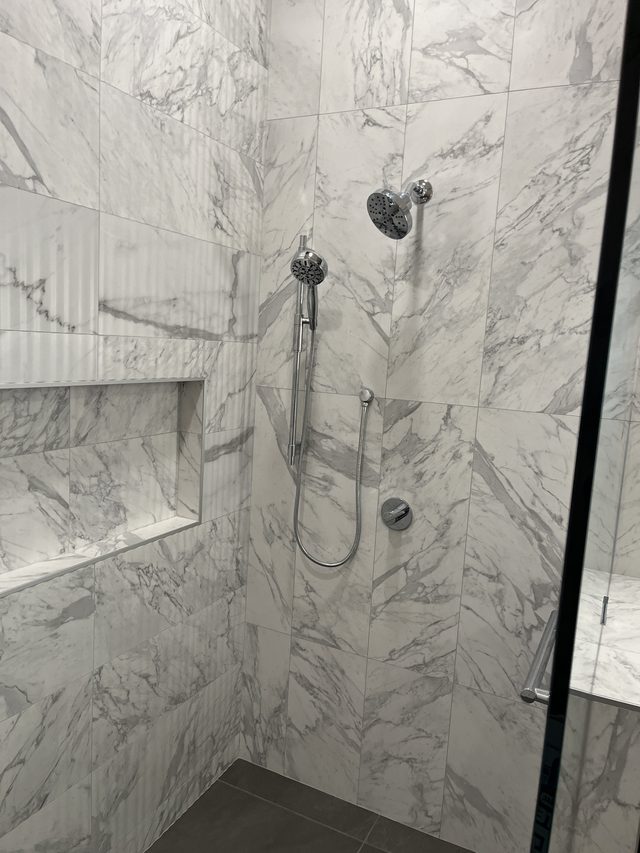 marble tile shower with handheld and rain shower fixtures