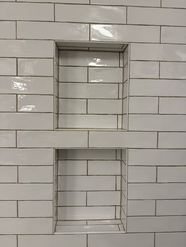 white subway tile shower wall with double recessed niche