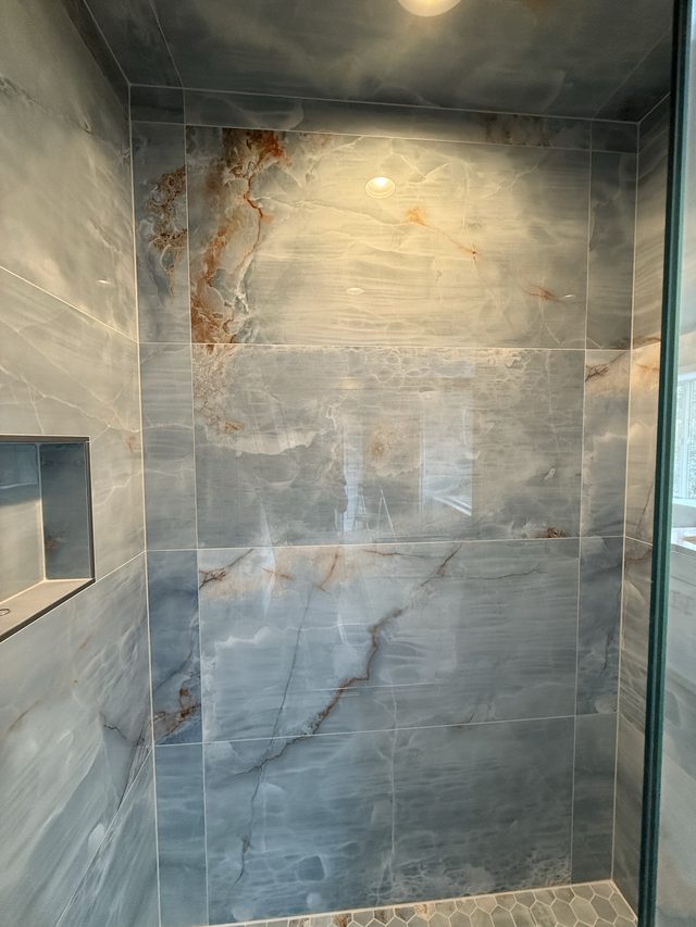 blue onyx-look marble tile shower wall with niche