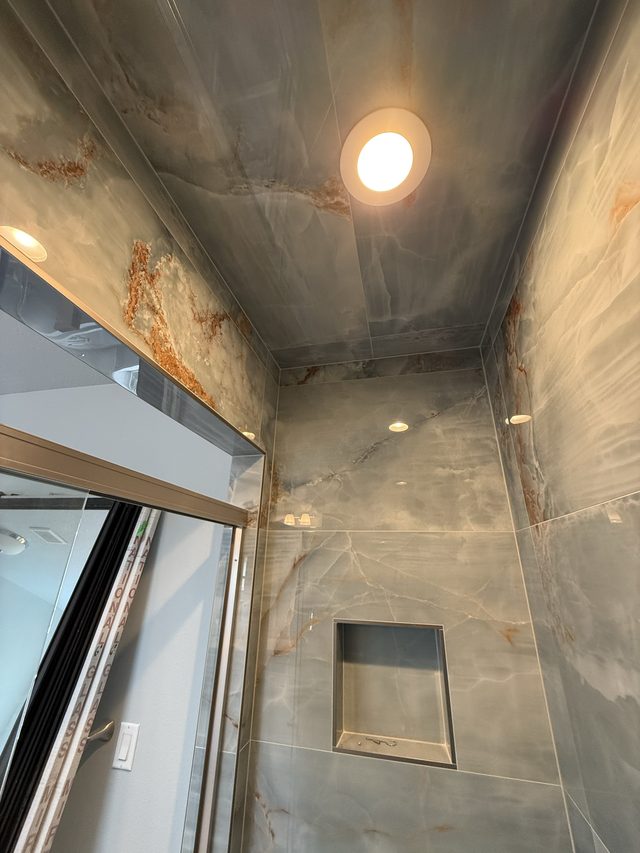 blue onyx-look tile shower ceiling and walls with light fixture
