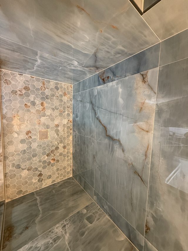 blue onyx-look tile shower with hexagon mosaic accent wall