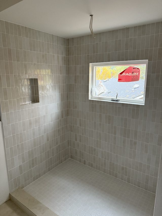 gray vertical-stack tile walk-in shower with window