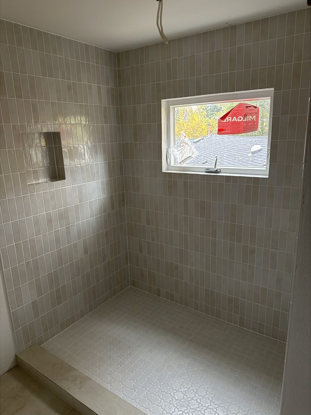gray tile shower with niche and window