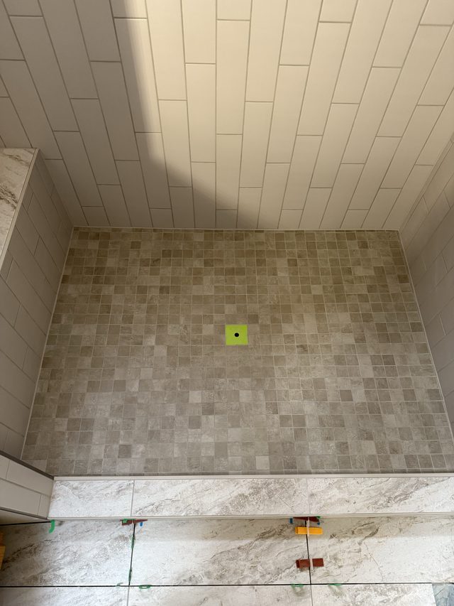 overhead view of mosaic shower floor and tiled walls