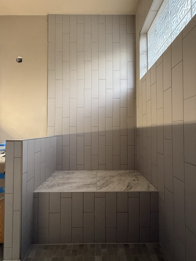 tiled shower with bench seat and glass-block window