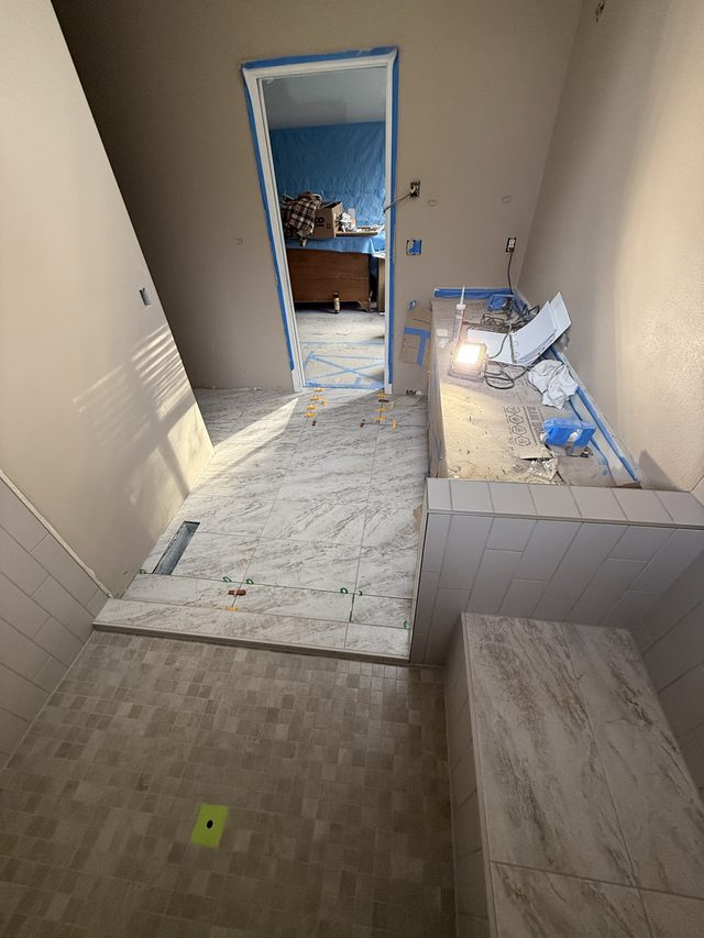 bathroom renovation with marble floor tile and doorway to adjacent room
