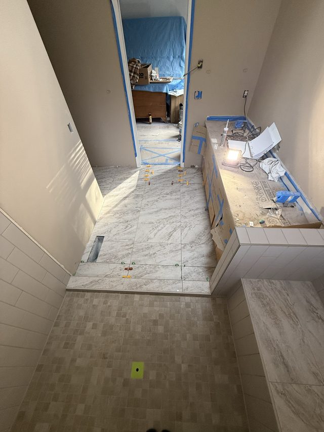 bathroom mid-renovation, marble-look tile floor and vanity wall