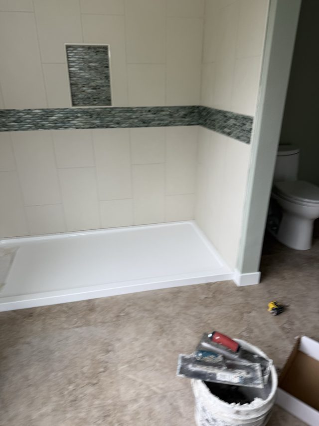 white tile walk-in shower with glass mosaic accent band and niche, white shower pan