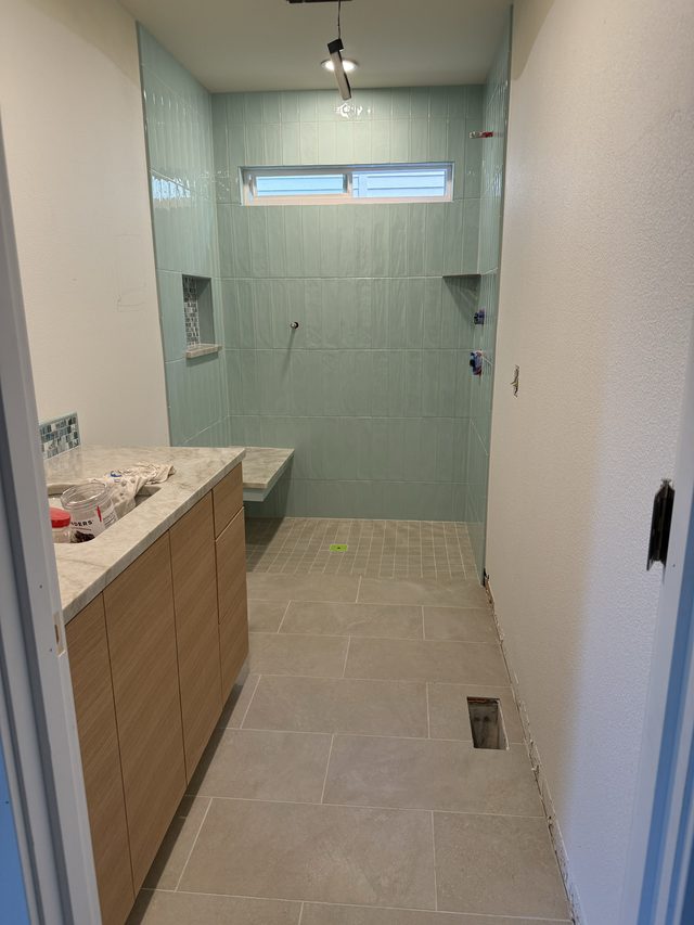 bathroom with vanity and teal-green tile walk-in shower