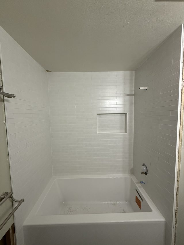 white subway tile tub/shower surround with niche over bathtub