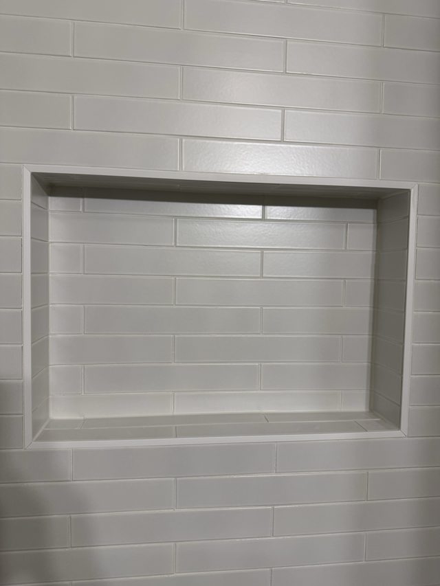 white subway tile shower wall with recessed niche