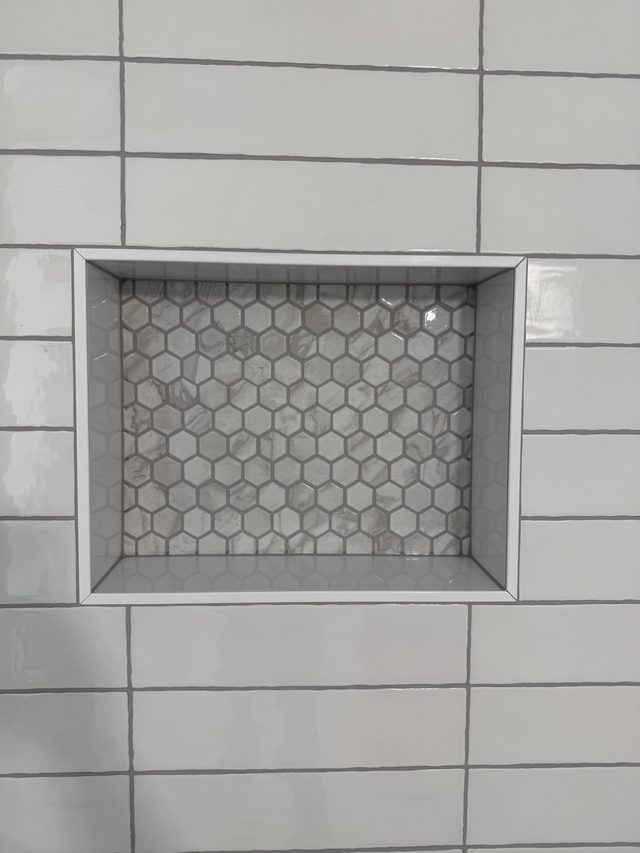 shower niche with hexagon mosaic tile in subway surround