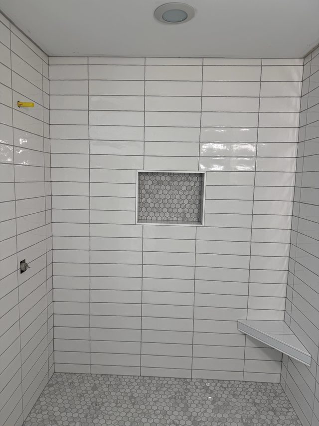 white tile shower, niche with hex mosaic, corner shelf, hex floor