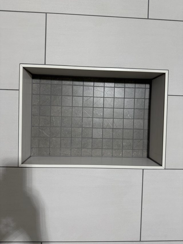 shower niche with gray mosaic tile back