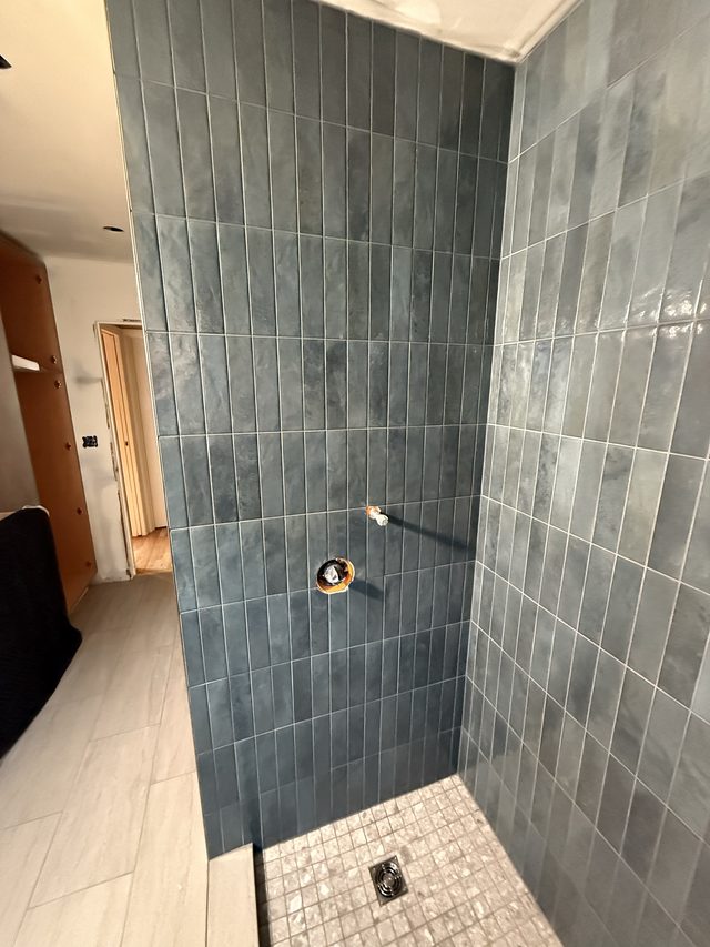 blue tiled shower with mosaic floor