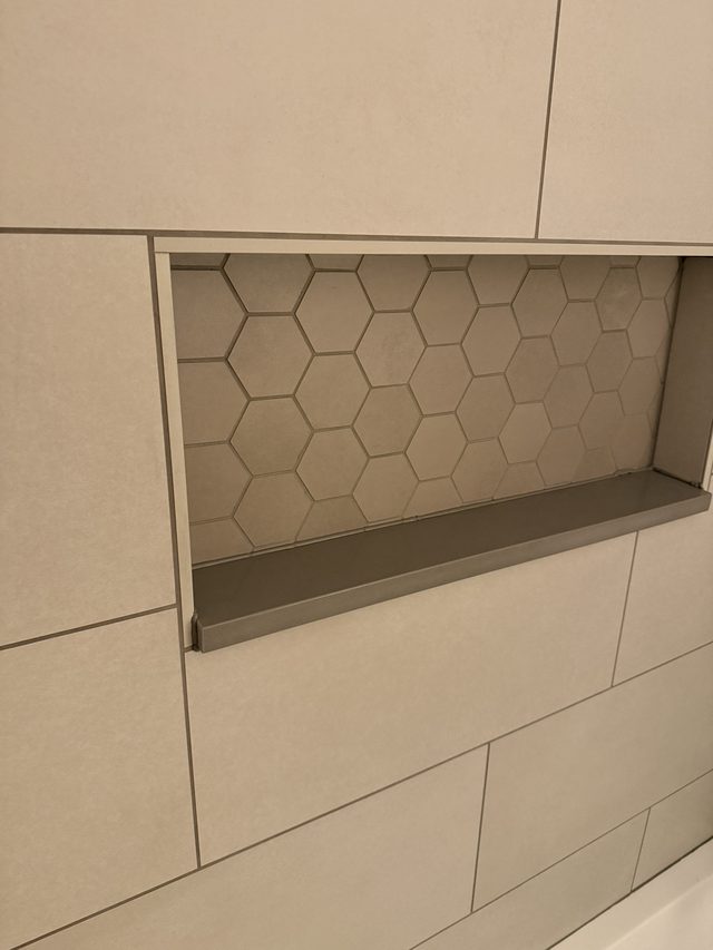 shower niche with hexagon tile and large-format wall tile