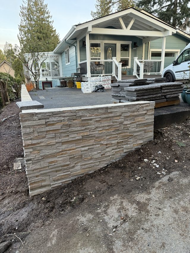 stacked-stone retaining wall in front of house with porch