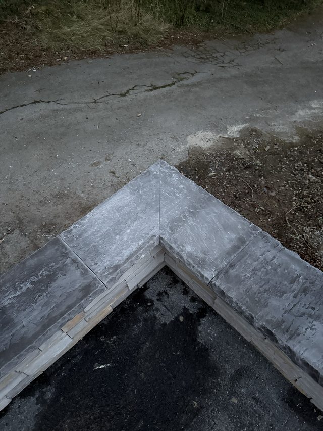 stone-capped wall corner over driveway, outdoor