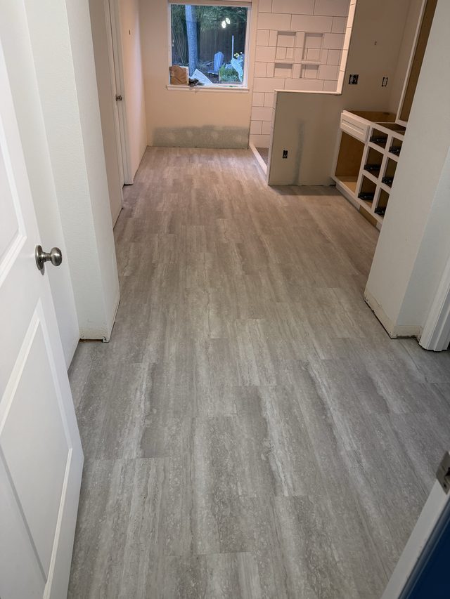gray plank tile floor leading toward kitchen area, floor is main subject