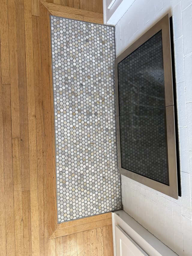 penny-tile hearth strip against hardwood floor