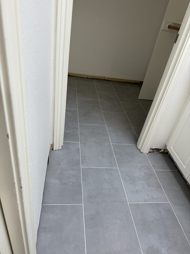 gray rectangular tile floor in hallway doorway, not a bathroom