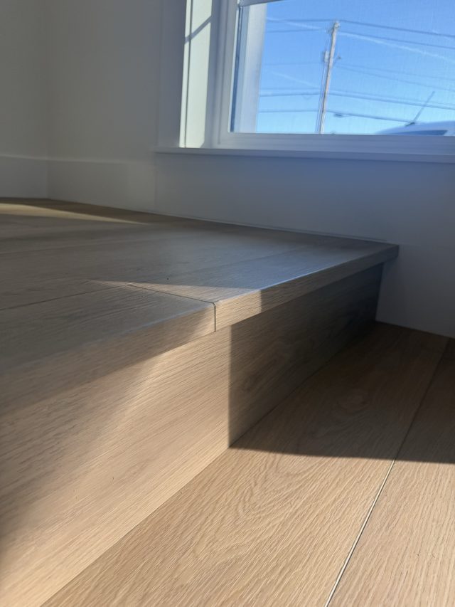 wood stair tread edge with hardwood floor by window