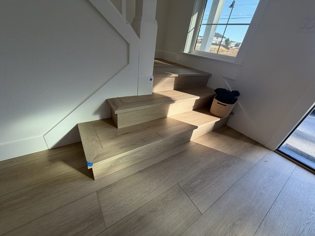 light wood staircase steps and hardwood landing floor