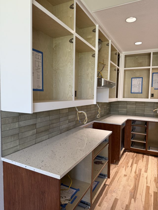 kitchen cabinets, quartz countertops and green linear tile backsplash