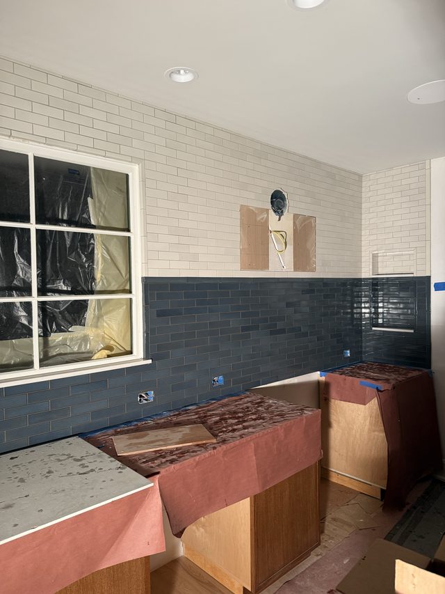 blue subway tile backsplash with white subway above, base cabinets