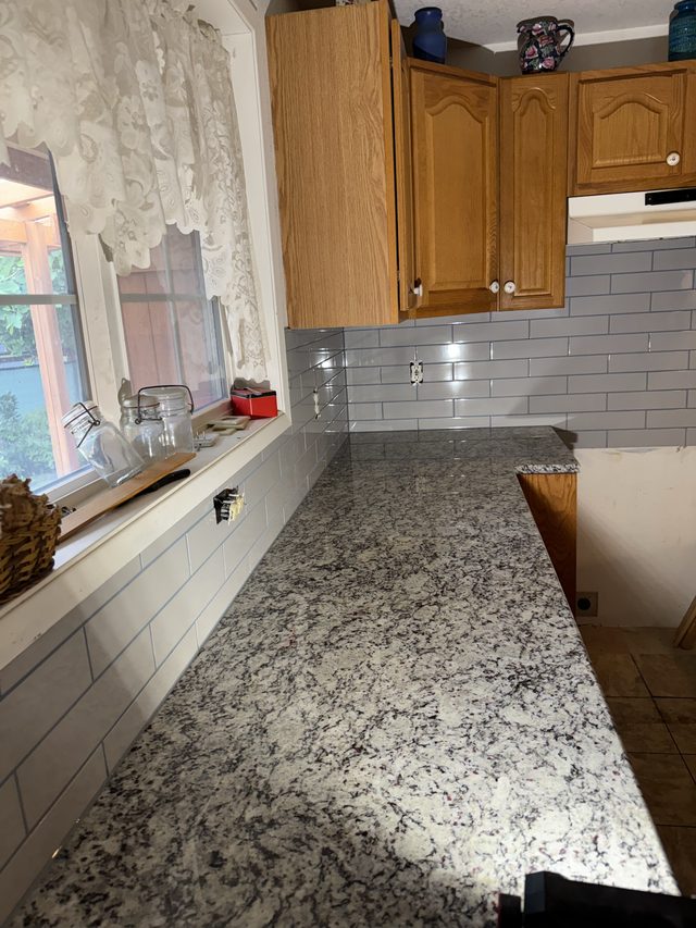 oak cabinets, granite countertop, white subway backsplash