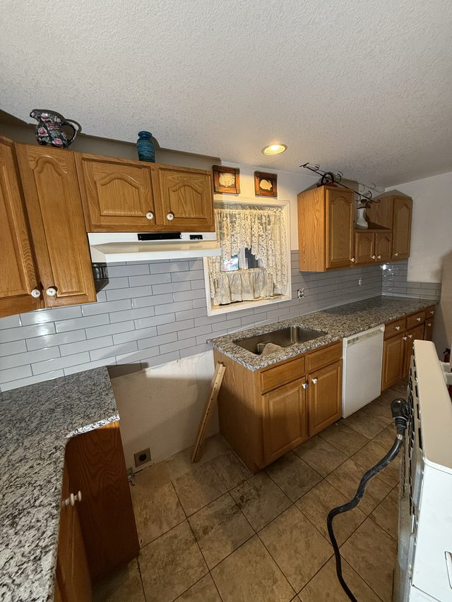 oak cabinets, sink, dishwasher, subway tile backsplash