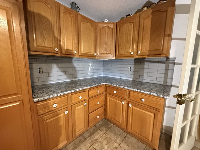 oak cabinets, granite counter, gray subway backsplash