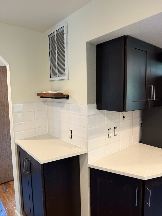 kitchen cabinets, white backsplash, light countertops