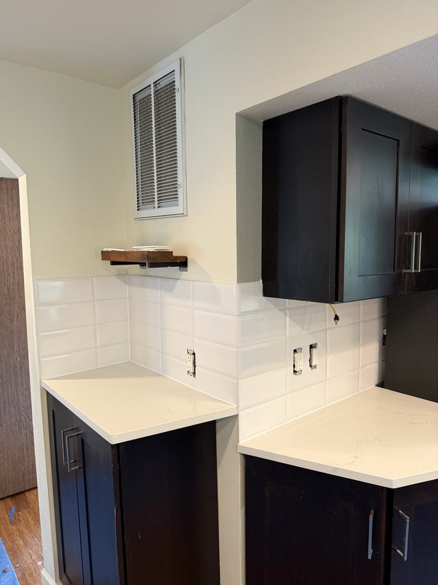 kitchen cabinets, white backsplash, light countertops