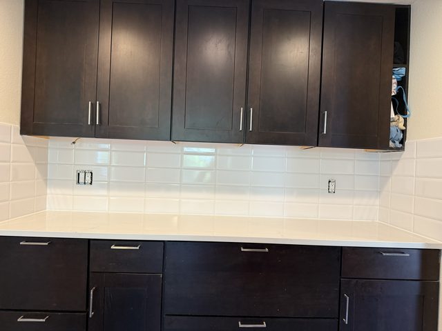 dark cabinets with white subway backsplash and counter