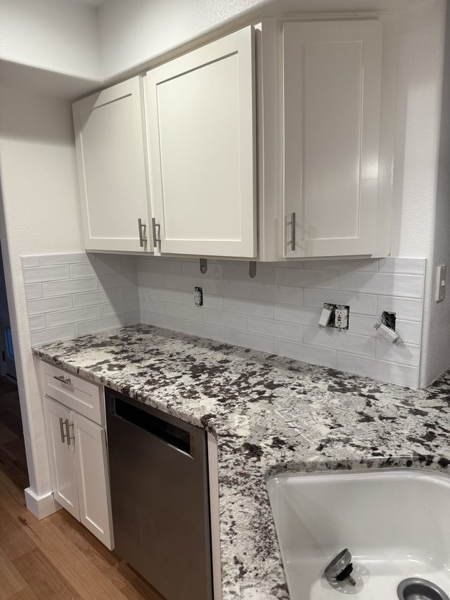 white cabinets, speckled granite counter, subway tile backsplash