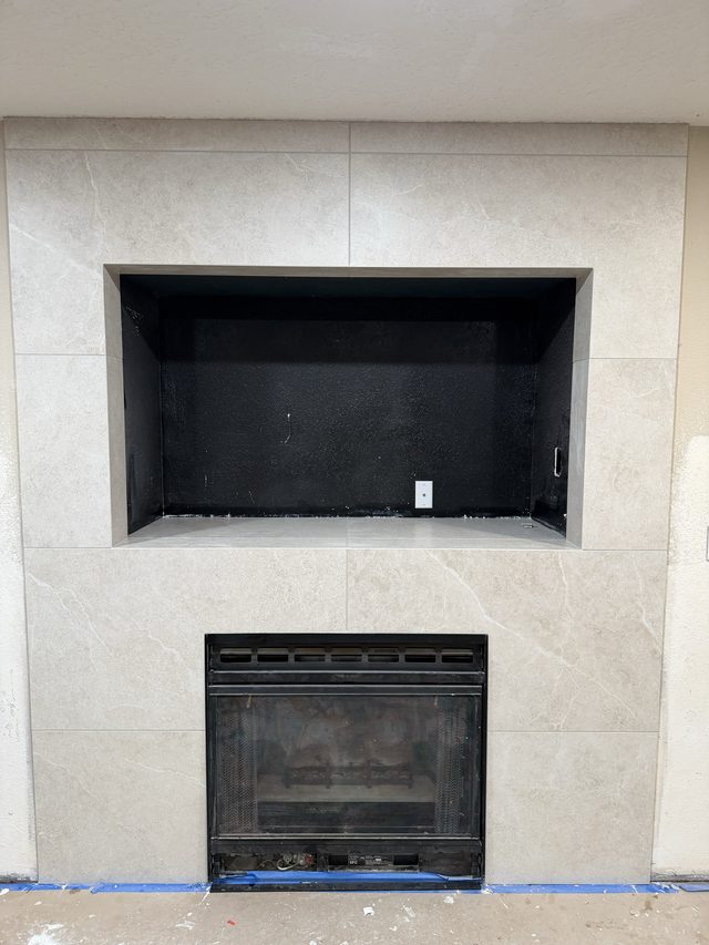 tiled fireplace surround with recessed niche above firebox