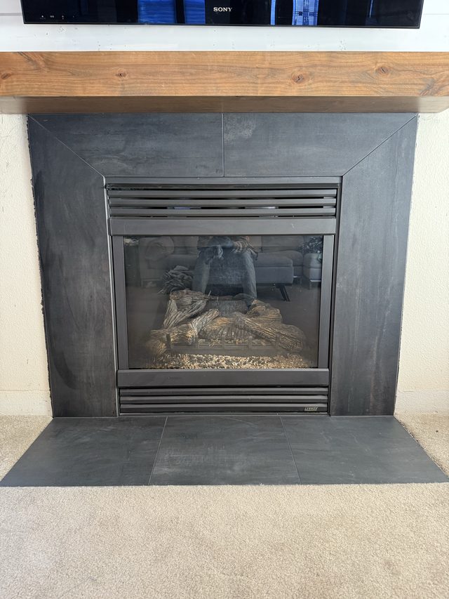 gas fireplace with slate tile surround and hearth in living area